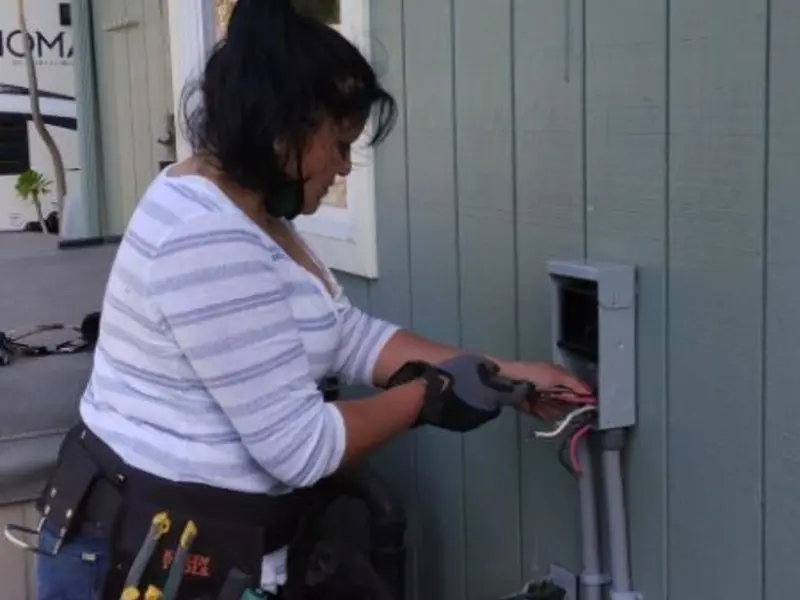 Licensed electrician wiring an exterior subpanel in Arab